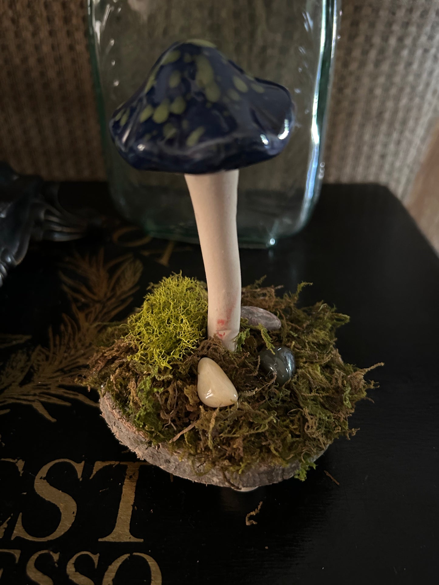 Whimsical blue and green mushroom with moss and gemstones