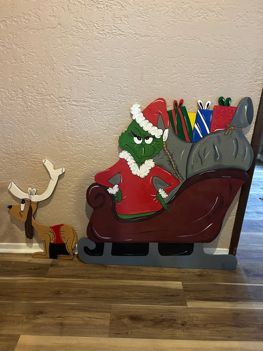 Grinch standing in sleigh